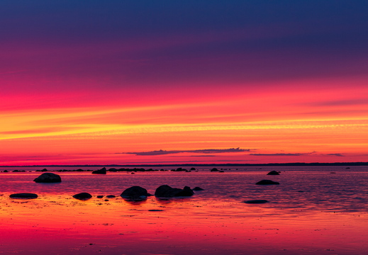 Veripunane päikeseloojang rannas panoraamina